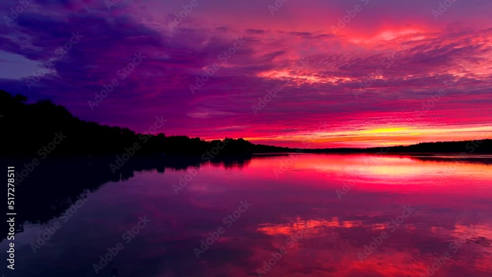 Amazing red sky mirrored in still waters at dawn, dynamic moving perspective.
Amazing red sky mirrored in still waters at dawn, dynamic moving perspective.