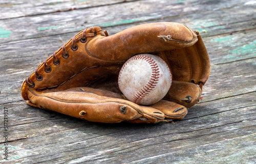 Photography Lets play ball. old baseball glove holds a worn baseball