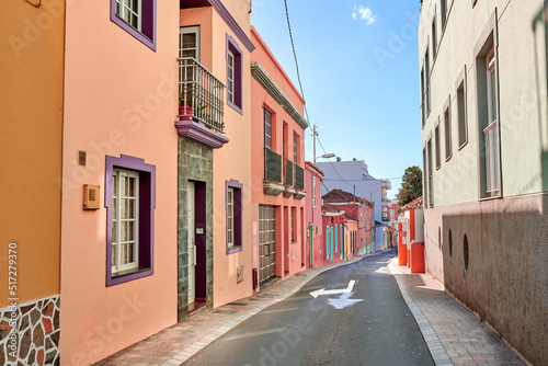 Fototapeta Naklejka Na Ścianę i Meble -  Historical city street view of residential houses in small and narrow alley or road in tropical Santa Cruz, La Palma. Village view of vibrant buildings in popular tourism destinations overseas
