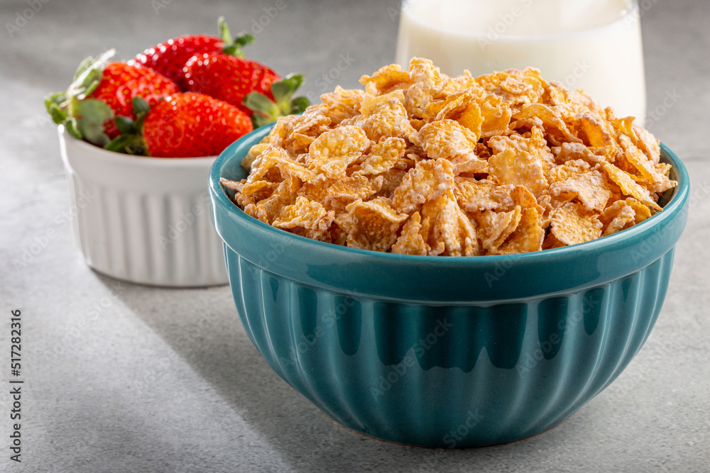 Corn flakes in the bowl with berries and milk on the table. Corn flakes in the bowl with berries and milk on the table.