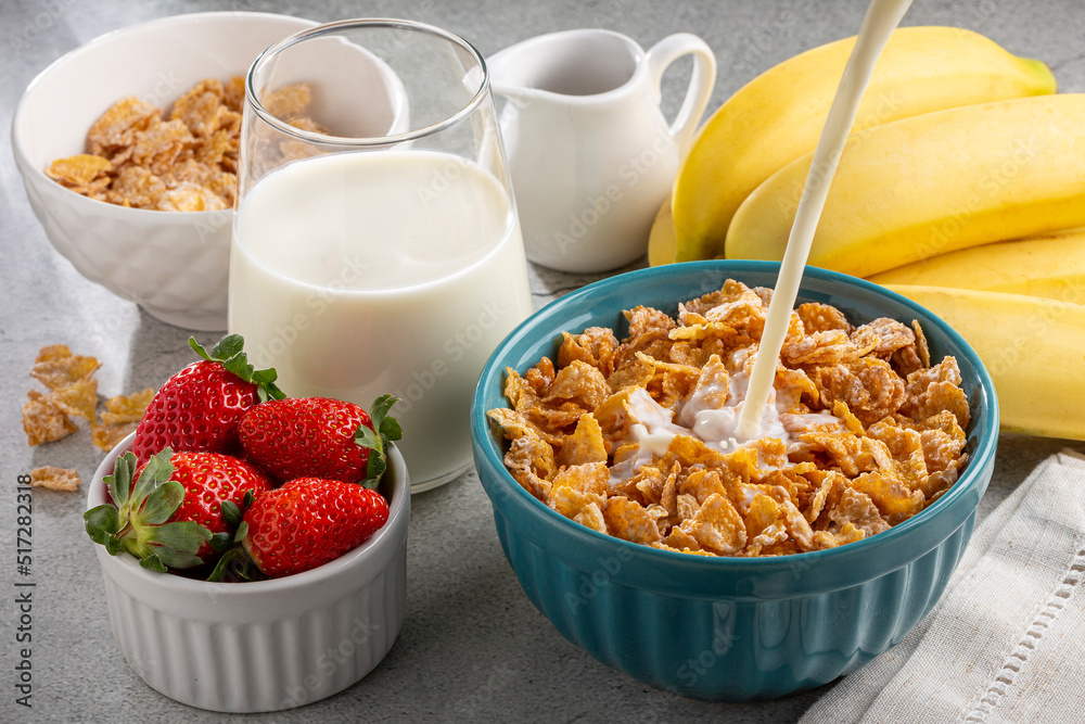 Corn flakes in the bowl with berries and milk on the table. Corn flakes in the bowl with berries and milk on the table.