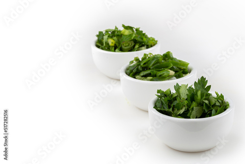 Sliced ​​cilantro, chives and parsley in ramekin.