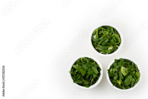 Sliced ​​cilantro, chives and parsley in ramekin.