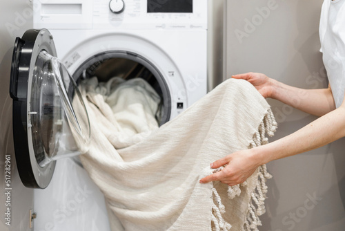 Konstfotografi Woman unloading laundry from white washing machine