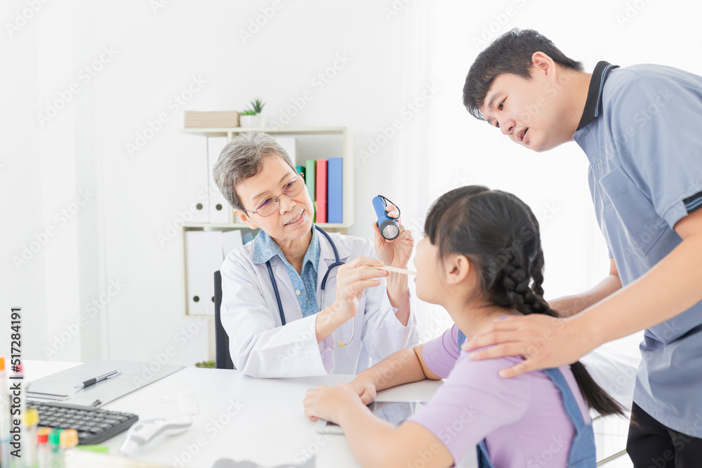 Doctor use tongue depressor and flashlight with children patient, he screening and diagnosis Doctor use tongue depressor and flashlight with children patient, he screening and diagnosis