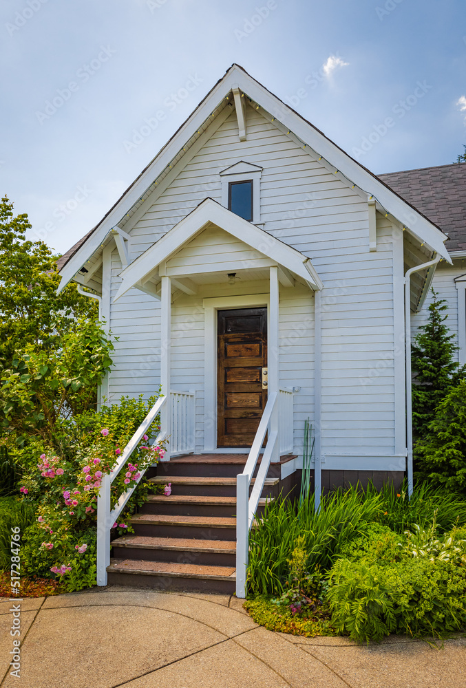 Obraz premium Entrance to a home through a beautiful garden with green lawn and flowers. House with garden design