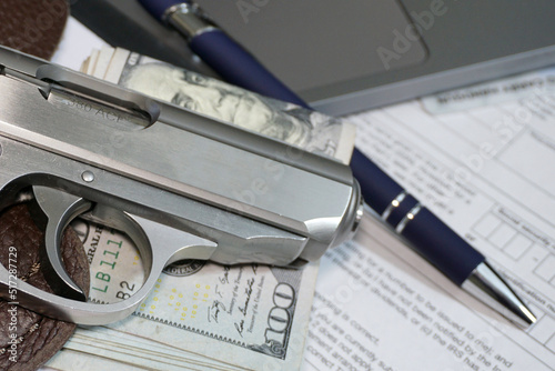 Small pistol and money in office environment photo