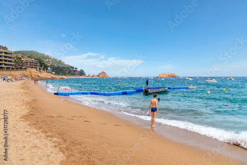 A boy stands at the shore of the Mediterranean Sea on the Platja Gran Playa Grande beach at Tossa de Mar, Spain, on the Costa Brava coast.