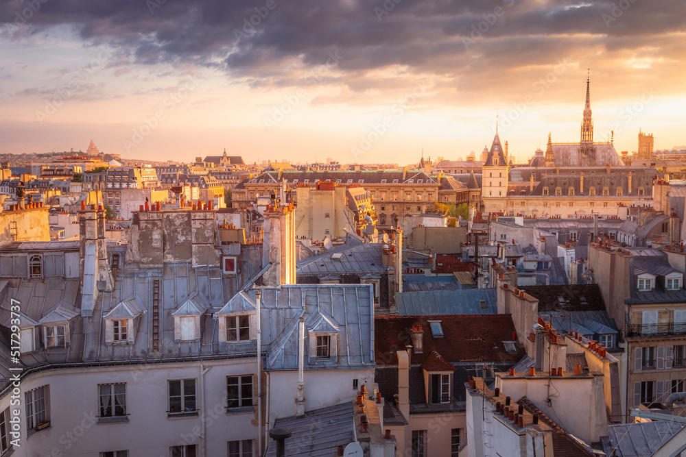 Above Paris roofs and attics at dramatic golden sunrise, France