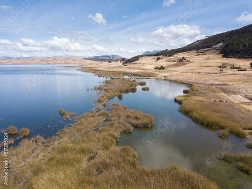 Aerial view of Huaypo Lake. Water source in the high Andes of Cusco Peru. Sunny day in Andean rural landscape.