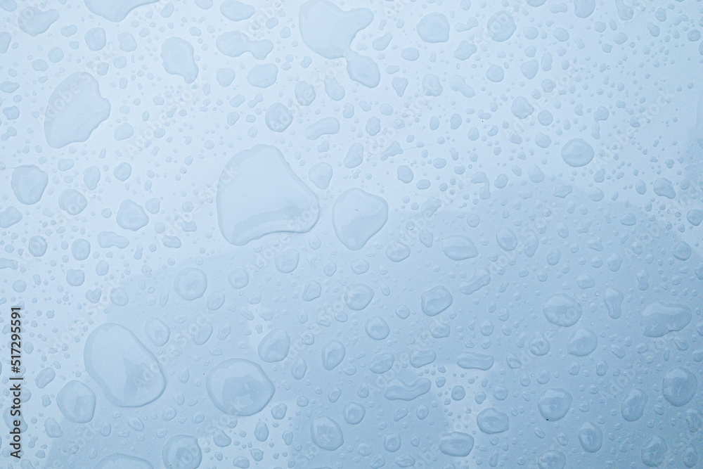 Clear water drops on transparent glass blue background 