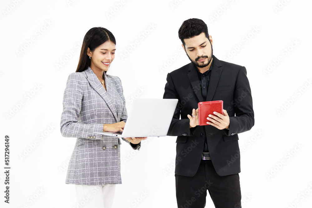 Studio shot Indian male businessman in formal suit holding working with tablet while Asian cheerful professional successful female businesswoman smiling holding laptop computer on white background Studio shot Indian male businessman in formal suit holding working with tablet while Asian cheerful professional successful female businesswoman smiling holding laptop computer on white background
