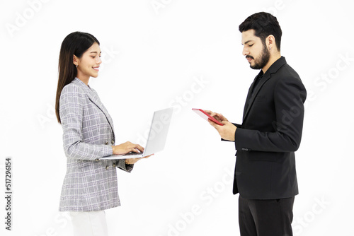 Studio shot Indian male businessman in formal suit holding working with tablet while Asian cheerful professional successful female businesswoman smiling holding laptop computer on white background