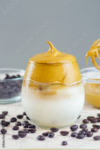 Kopi dalgona or dalgona coffee.made by mixing instant coffee, sugar, and hot water then whipped until it becomes creamy and then added to cold or hot milk photo