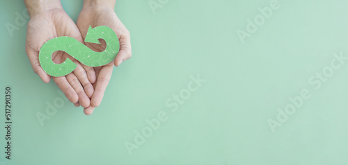 Hands holding green infinity arrow symbol, circular economy, sustainable and responsible business growth concept photo