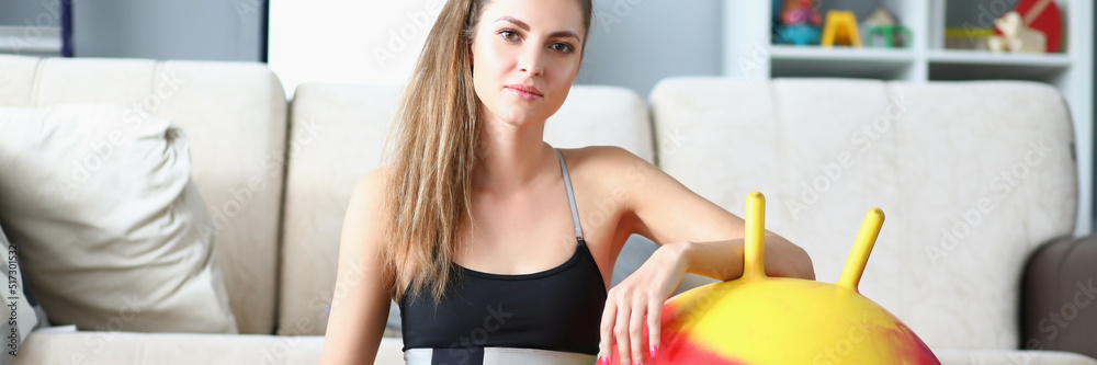 Fototapeta premium Attractive young woman pose with dumbbells and ball on floor