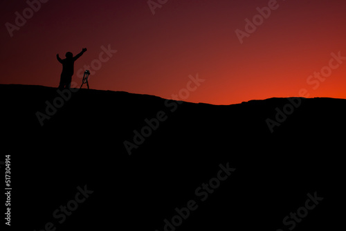 silhouette of a person standing on a rock © Aewaew
