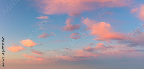 Pastel light pink clouds in the blue sky during dawn sunset, sky background photo