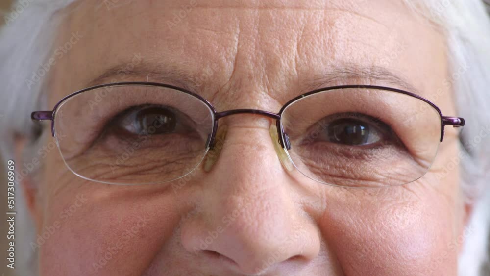 Closeup of senior womans eyes thinking of a happy memory and daydreaming. Portrait of an old female staring with hope for humanity. The detail of a mature ladys face wearing glasses