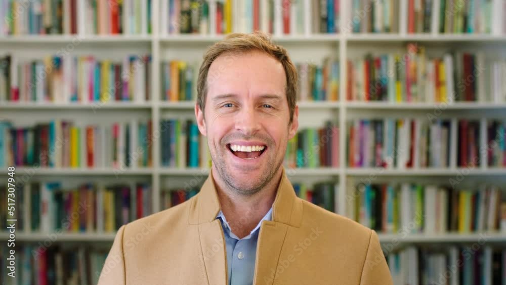 Portrait of laughing teacher showing a fun and playful facial expression in school library. Headshot of mature man or confident and trustworthy lecturer giggling at a funny joke in a community centre
