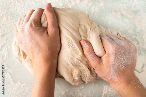 hands in flour crumple the dough for pizza or pies  the process of cooking bakery products