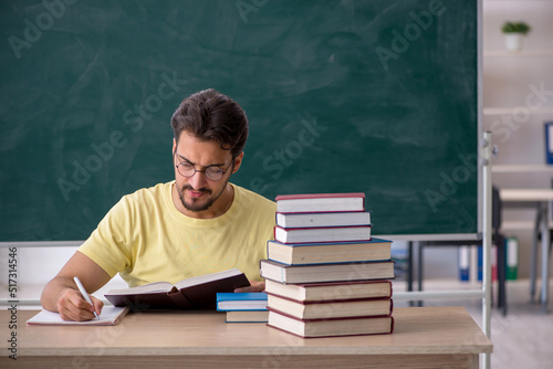 Young male student preparing for exams in the classroom