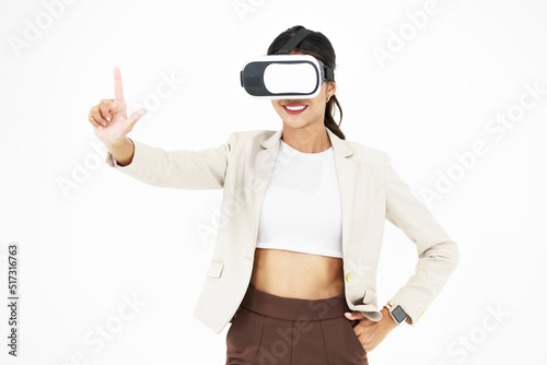 Studio shot of Millennial Asian smart professional successful businesswoman ceo entrepreneur wearing virtual reality VR goggles headset standing smiling holding hand touching air on white background © Bangkok Click Studio