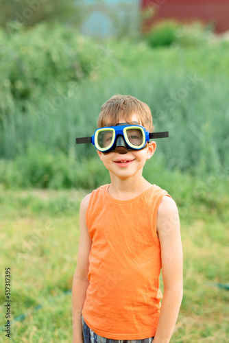 portrait of a boy outdoors in swimming goggles