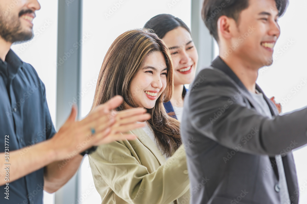 Group of millennial Asian young professional successful female businesswomen and Indian bearded male businessman in formal suit standing smiling celebrating winning victory together. Group of millennial Asian young professional successful female businesswomen and Indian bearded male businessman in formal suit standing smiling celebrating winning victory together.