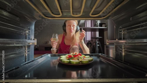 Female cook salat in oven at the kitchen