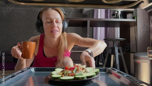 Female cook salat in oven at the kitchen