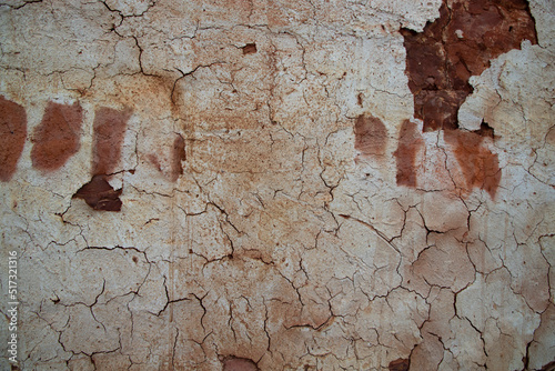 The texture of a brown concrete wall with cracks and scratches can be used as a background