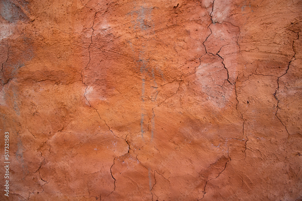 Naklejka premium The texture of a red concrete wall with cracks and scratches can be used as a background