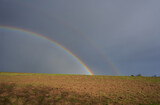rainbow landscape,two rainbows in the black sky in the field in spring