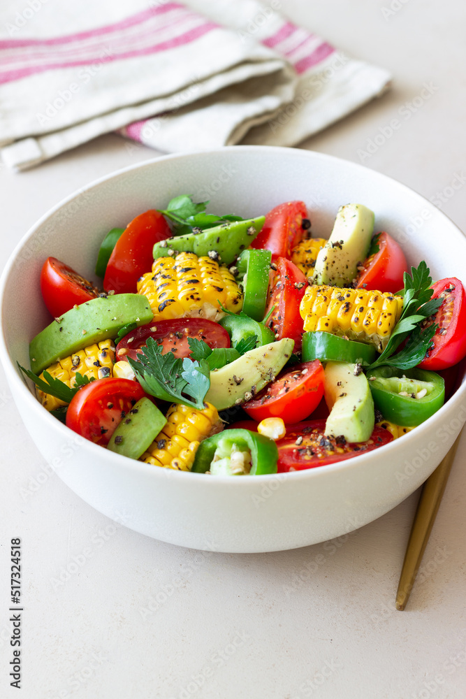 Salad with corn, avocado, tomatoes, peppers and parsley. Healthy eating. Vegetarian food.