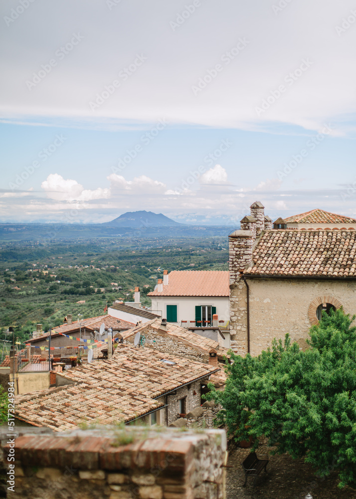 Top view of the Italian village of Nerola against the backdrop of a green valley and mountains. Ancient European architecture, old roof tiles.