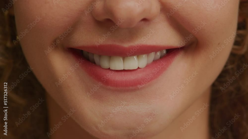 Close up of a charming woman smile with perfect natural teeth and bright lipstick