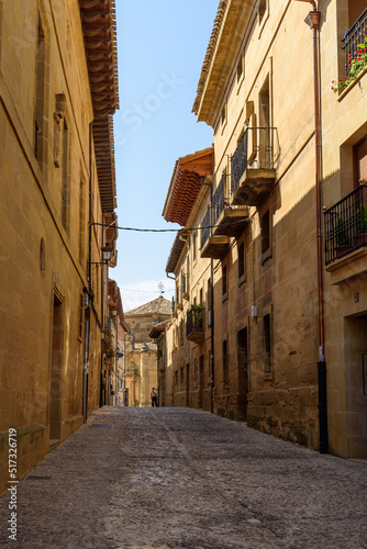 Fototapeta Naklejka Na Ścianę i Meble -  Cobblestoned street in the medieval town of Briones, Rioja, Spain. Picturesque And Narrow Streets On A Sunny Day. Architecture, Art, History, Travel