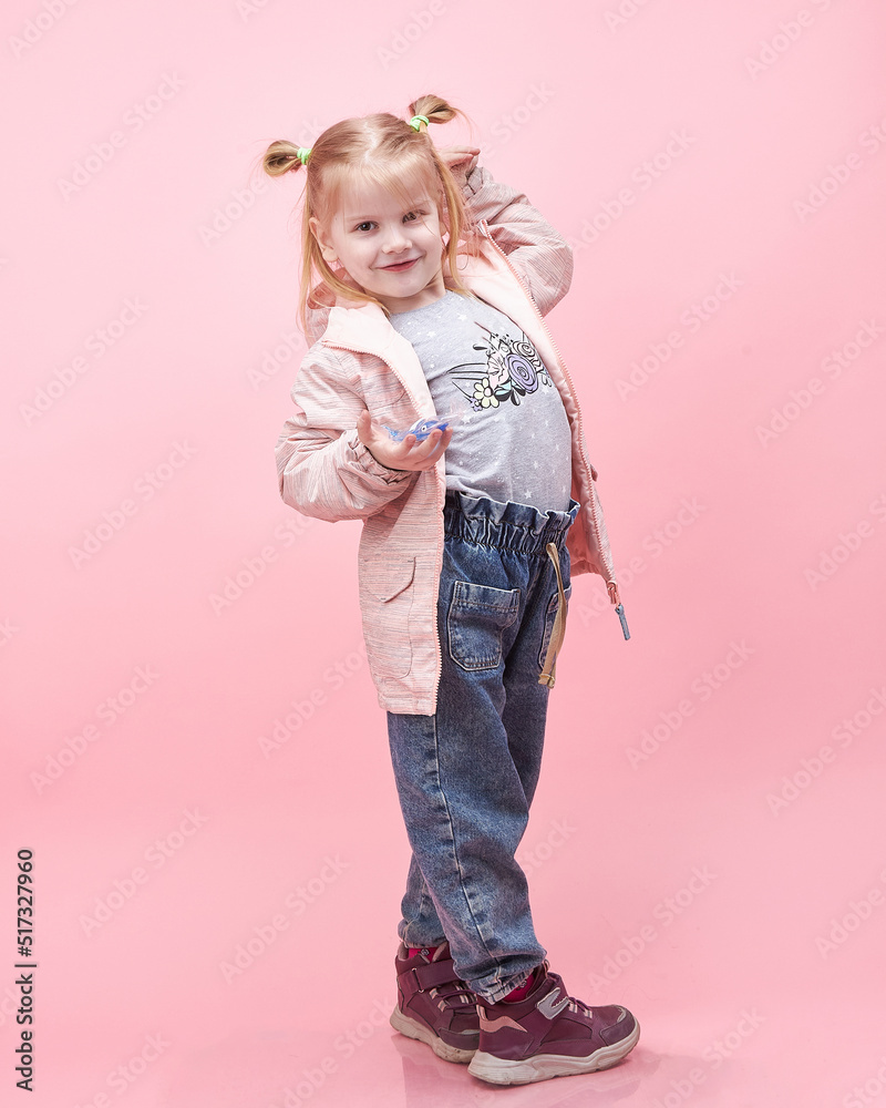 a child in a jacket on a pink background. a child in a jacket on a pink background.