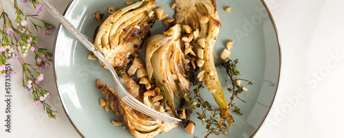 plate with baked fennel with almonds and thyme on the table