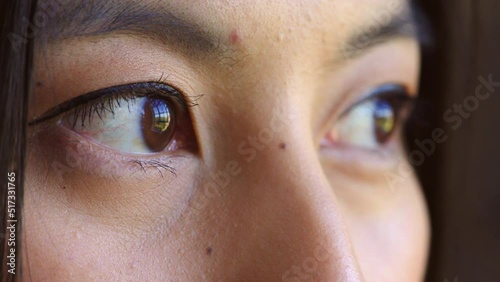 Closeup of womans eyes showing sadness or stress while looking outside, scared with social anxiety. Headshot, face detail of woman watching, dreaming or thinking of past memory, longing to escape