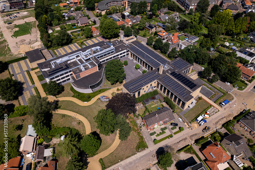 School building in The Netherlands of Marianum gymnasium seen from above. Aerial of educational building with solar panels on the rooftops.