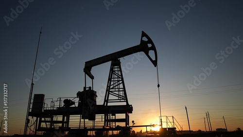 oil production. silhouette oil and gas production rig at sunset glare. oilfield business a extraction concept. oil extraction pump. Oil lifestyle pump rig