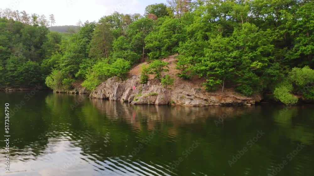 Slowly we float on a boat and look at the nature. Rocky shore of a river or lake, overgrown with vegetation and trees. Water travel Slowly we float on a boat and look at the nature. Rocky shore of a river or lake, overgrown with vegetation and trees. Water travel