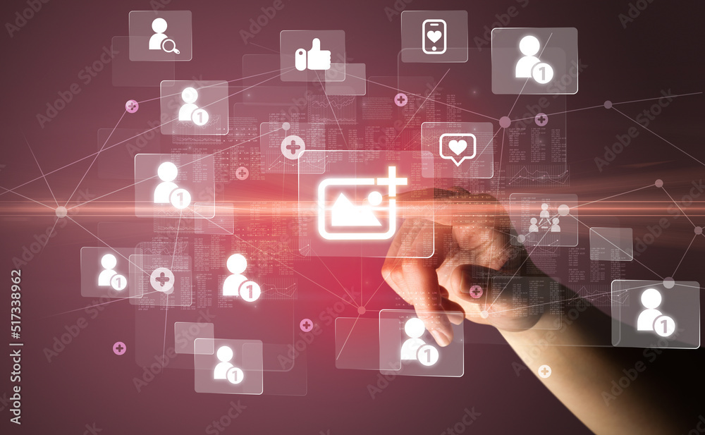 Hand pressing social media multimedia application screen with media icons on futuristic concept Hand pressing social media multimedia application screen with media icons on futuristic concept