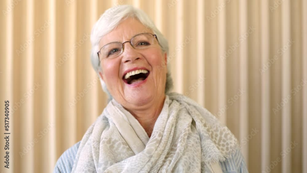 Portrait of a laughing older woman looking happy inside an empty room. Face closeup of an elderly female with glasses in her home enjoying retirement. Headshot of joyful senior lady with a soft scarf Portrait of a laughing older woman looking happy inside an empty room. Face closeup of an elderly female with glasses in her home enjoying retirement. Headshot of joyful senior lady with a soft scarf