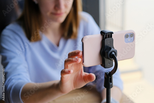 Close-up of a phone on a tripod filming a girl blogging