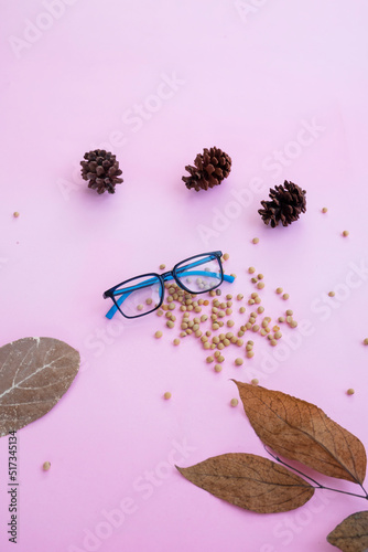 Fashion and beauty concept lying flat with square glasses, women's accessories on pink background.