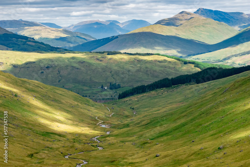 Beautiful mountainous landscape of the Trossachs National Park in Scotland in the summer with hills, valleys, river streams, reservoirs and mountain peaks