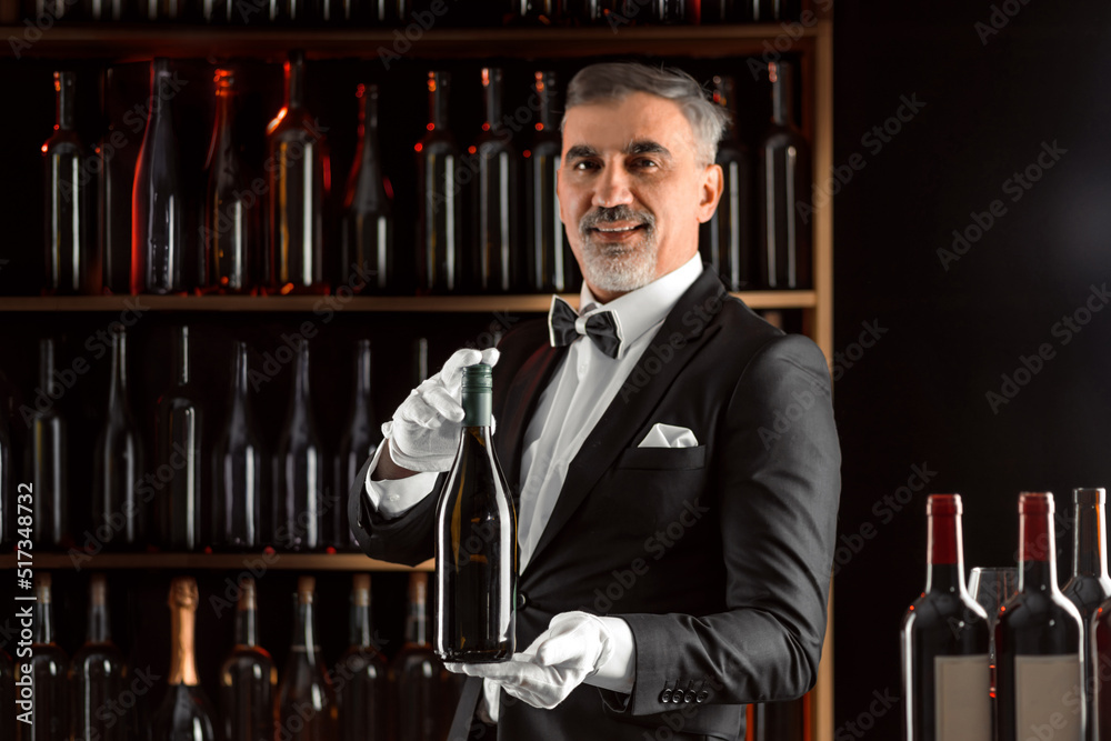 Foto de Elegant waiter sommelier wine steward with a bottle of wine